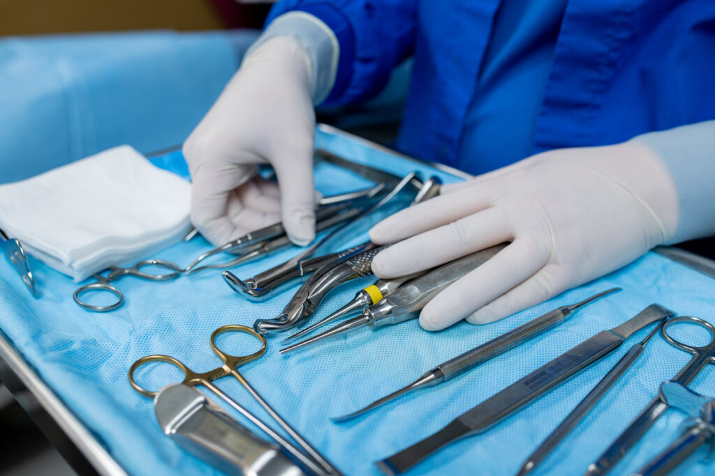 surgical assistant adjusting surgical tools on a tray