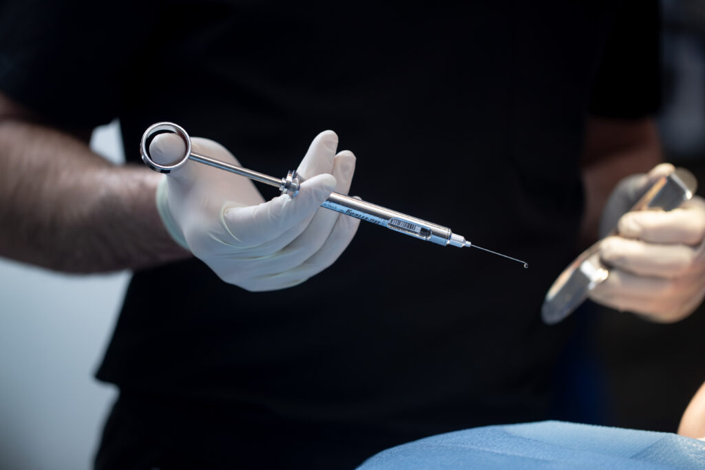 gloved hands holding surgical tools