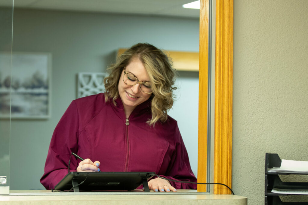 patient standing at the counter signing for payment