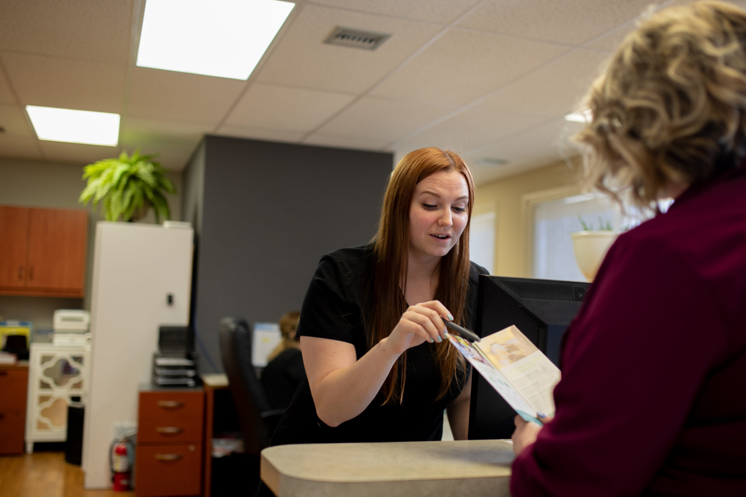 administrative personnel explaining insurance information to a patient