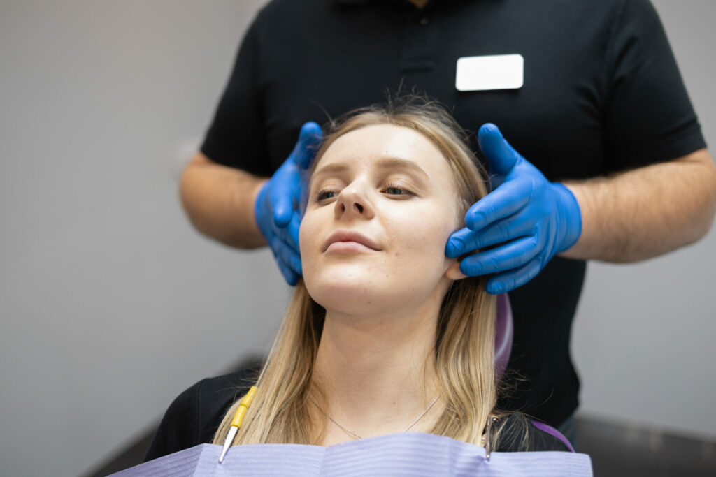 surgeon with hands on the sides of a patient's face